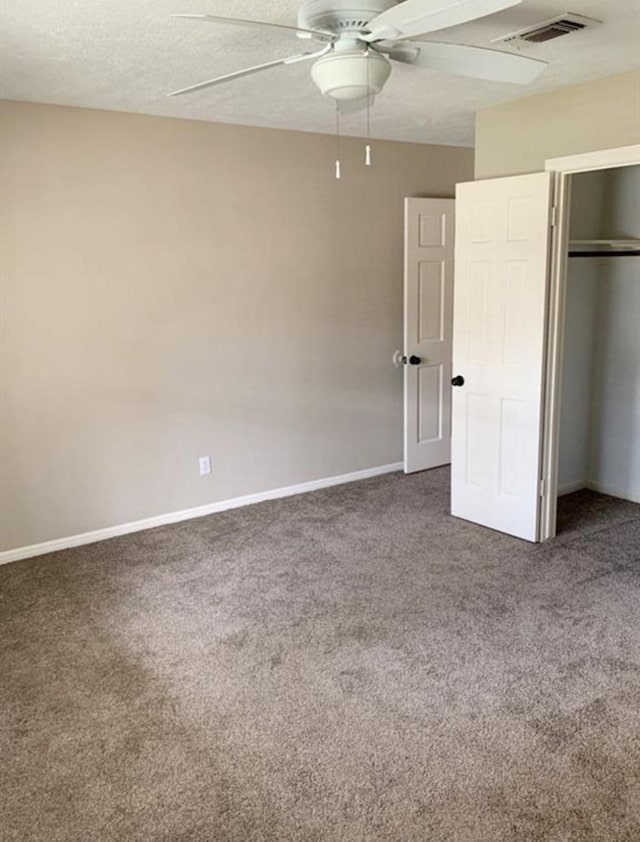 unfurnished bedroom with a closet, visible vents, a textured ceiling, and carpet flooring