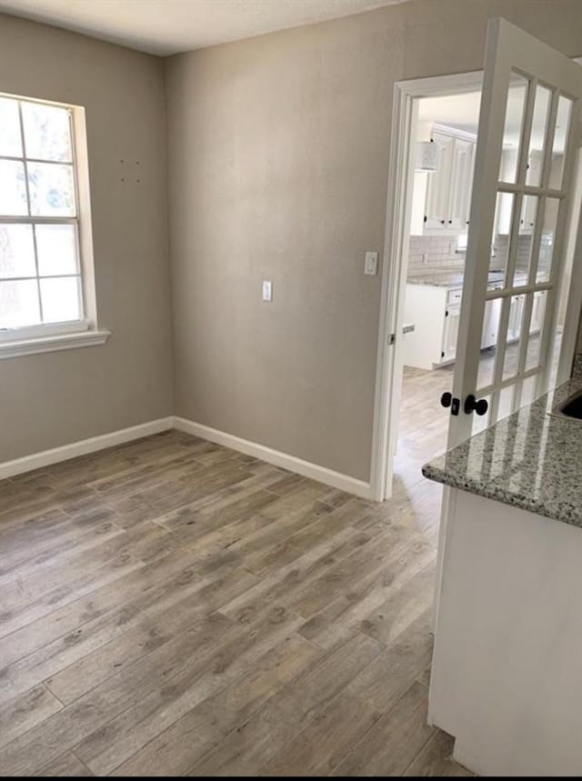 empty room with light wood-style floors and baseboards