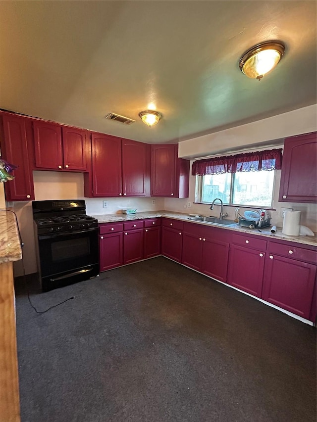 kitchen featuring a sink, black gas range, visible vents, and reddish brown cabinets