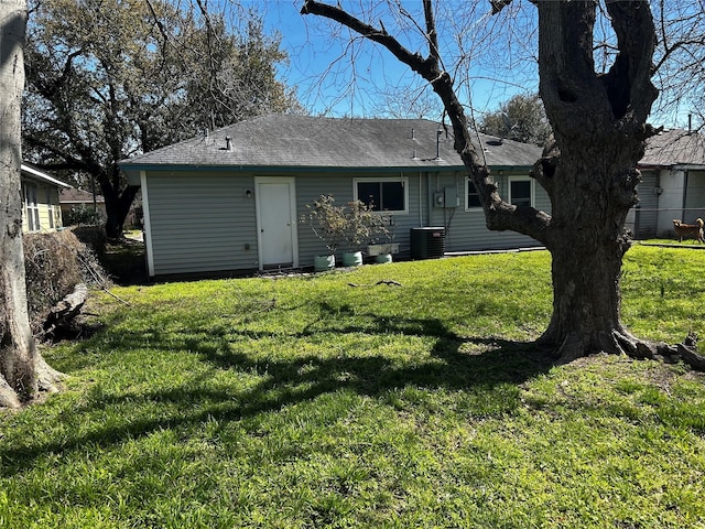 back of house with a lawn and central air condition unit