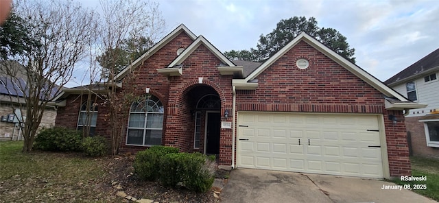 view of front of home featuring a garage, concrete driveway, and brick siding