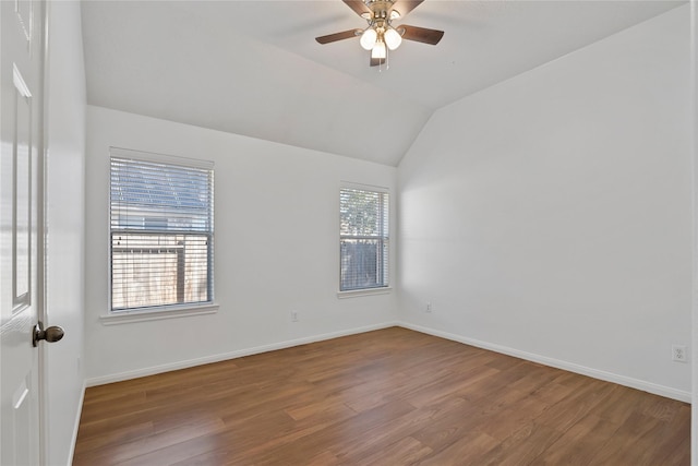 spare room featuring ceiling fan, vaulted ceiling, baseboards, and wood finished floors