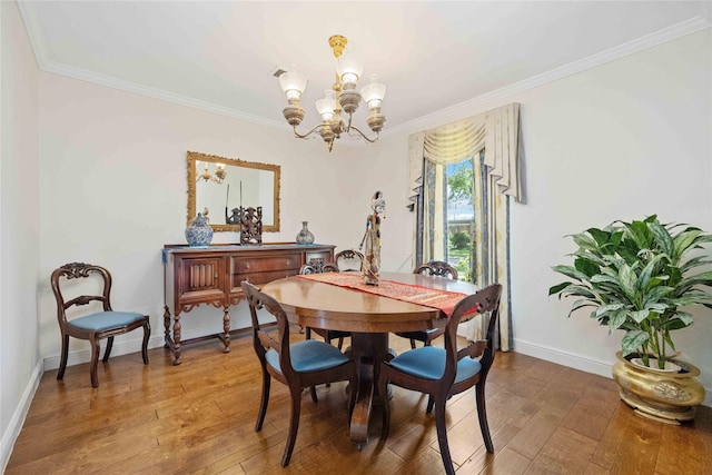 dining space with a chandelier, crown molding, and wood finished floors