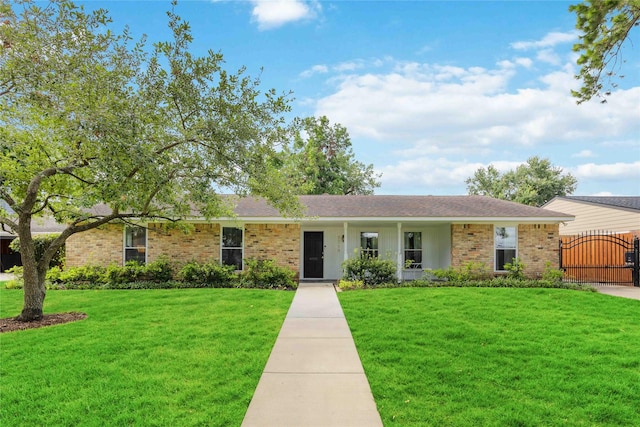 ranch-style home with a front yard, a shingled roof, a gate, and brick siding