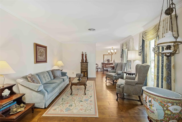 living room featuring dark wood-style floors, visible vents, ornamental molding, and an inviting chandelier