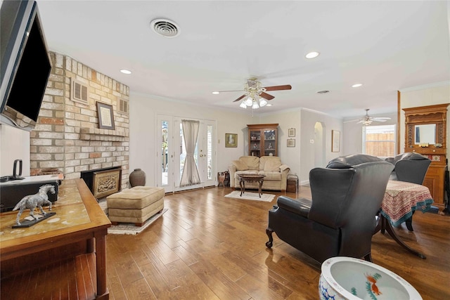 living area featuring crown molding, visible vents, and wood finished floors