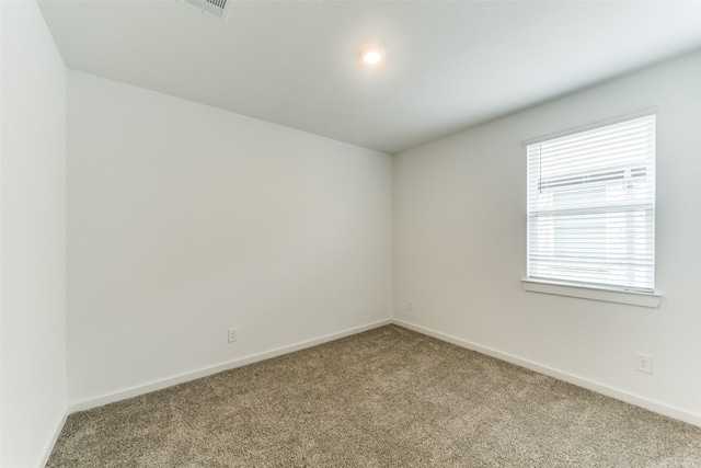 carpeted empty room featuring baseboards