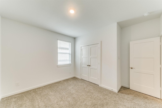 unfurnished bedroom featuring carpet floors, a closet, and baseboards