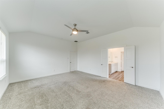 unfurnished bedroom with lofted ceiling, visible vents, light carpet, ceiling fan, and baseboards