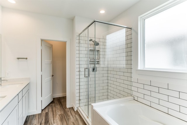 full bath featuring recessed lighting, a sink, a shower stall, wood finished floors, and a bath