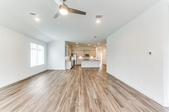 unfurnished living room featuring light wood-style floors, baseboards, and visible vents