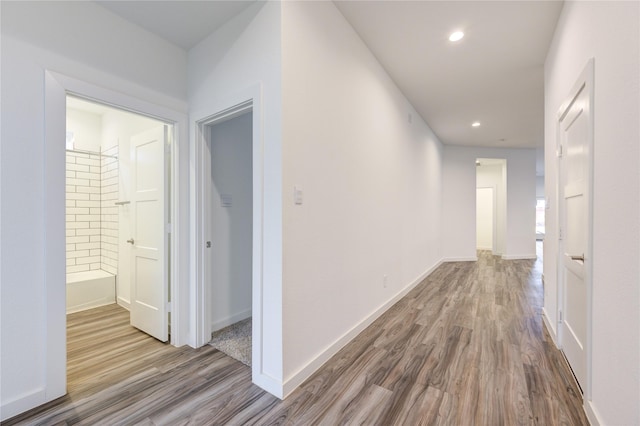 hallway featuring recessed lighting, baseboards, and wood finished floors