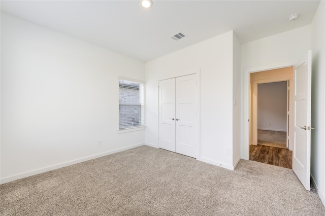 unfurnished bedroom with a closet, visible vents, baseboards, and carpet flooring