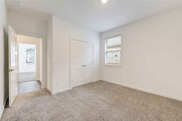 unfurnished bedroom featuring a closet, carpet, and baseboards