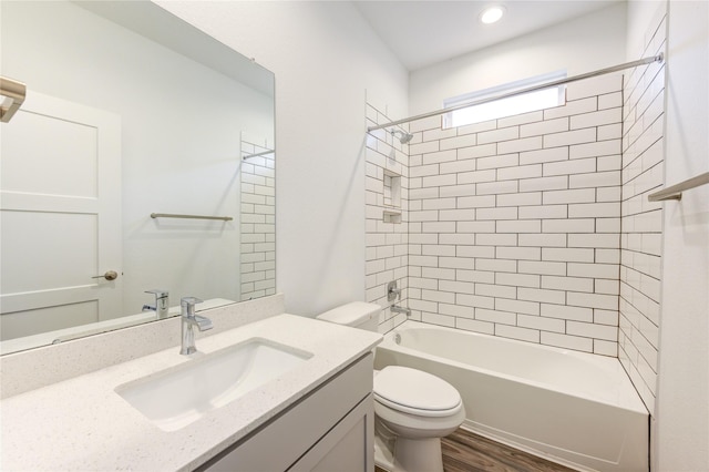 bathroom featuring toilet, washtub / shower combination, wood finished floors, and vanity