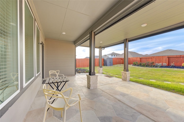 view of patio / terrace with a fenced backyard, an outdoor structure, and a storage shed