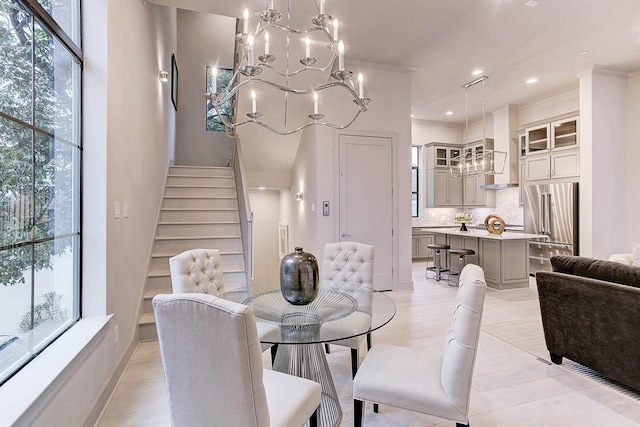 dining area with plenty of natural light, stairs, and a notable chandelier