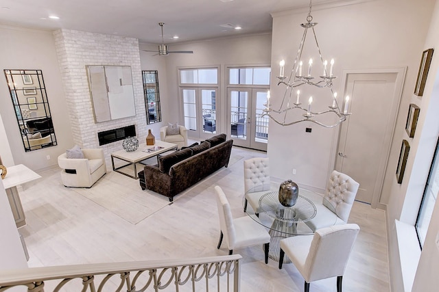 living room featuring recessed lighting, a ceiling fan, ornamental molding, french doors, and a brick fireplace