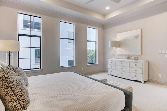 bedroom with a tray ceiling, crown molding, recessed lighting, light carpet, and baseboards