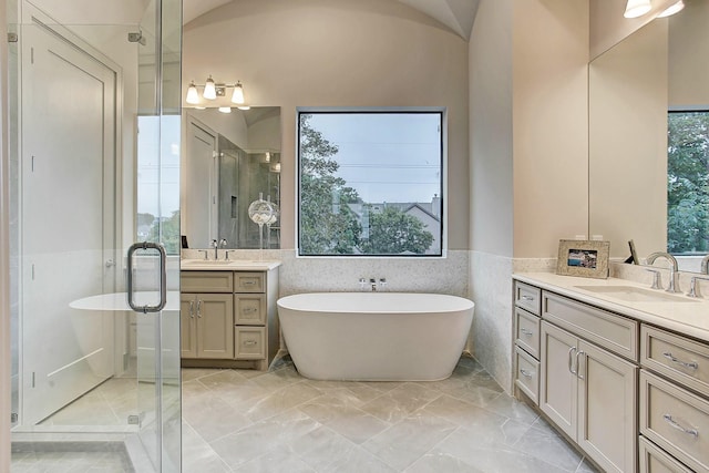 full bathroom with a shower stall, two vanities, and a sink