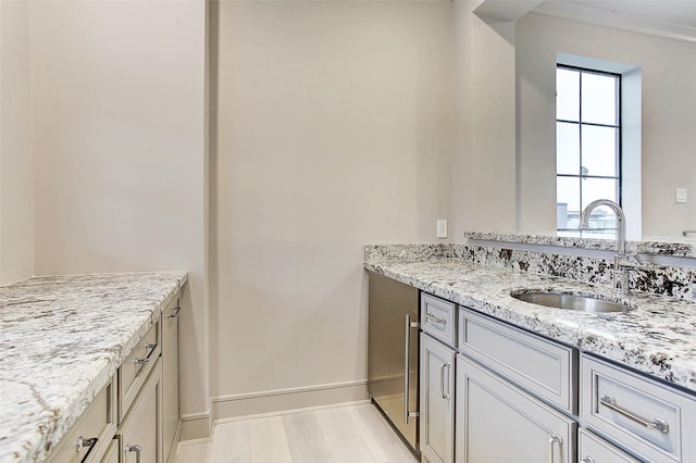 bathroom with wood finished floors, vanity, and baseboards