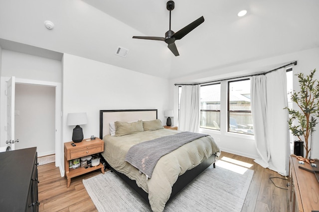 bedroom featuring lofted ceiling, a ceiling fan, baseboards, visible vents, and light wood-style floors