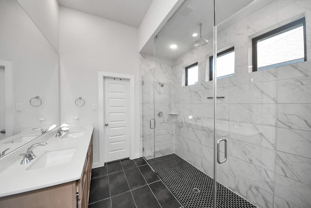 full bathroom featuring double vanity, a shower stall, and a sink