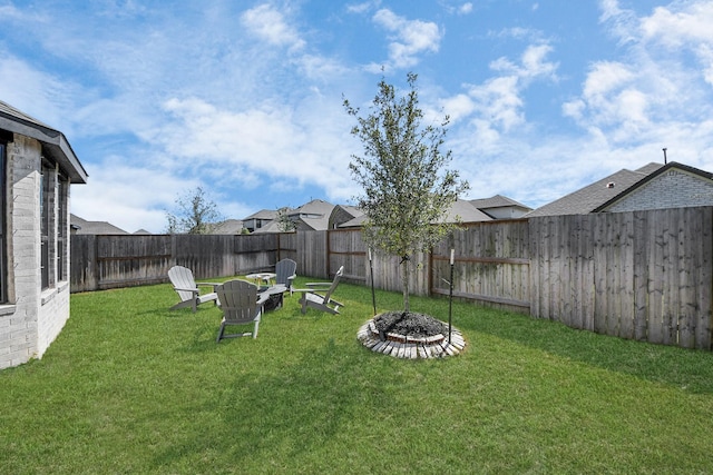 view of yard featuring a fenced backyard and a fire pit