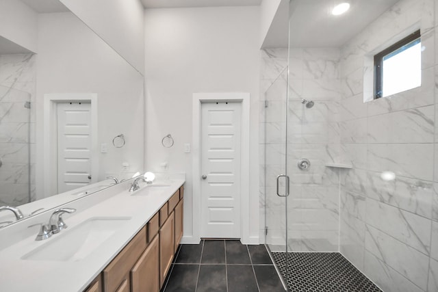 full bathroom with double vanity, a marble finish shower, and a sink