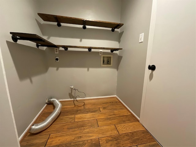 clothes washing area with hookup for a washing machine, wood-type flooring, hookup for an electric dryer, laundry area, and baseboards