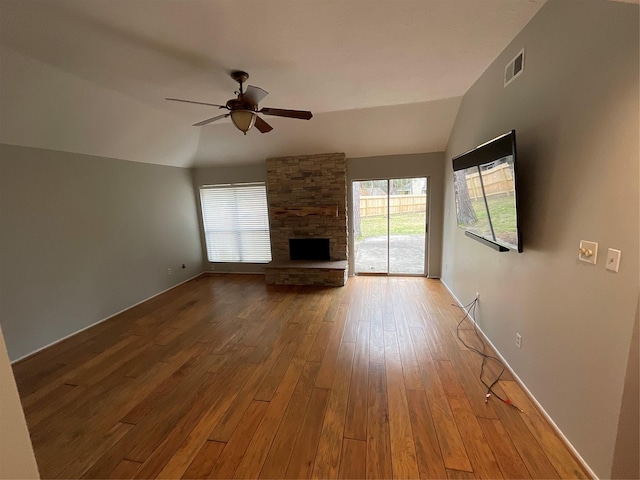 unfurnished living room featuring a fireplace, wood-type flooring, visible vents, a ceiling fan, and vaulted ceiling