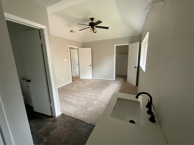 bathroom with baseboards, visible vents, ceiling fan, vaulted ceiling, and a sink