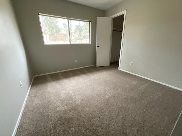 unfurnished bedroom featuring a closet, carpet flooring, and baseboards