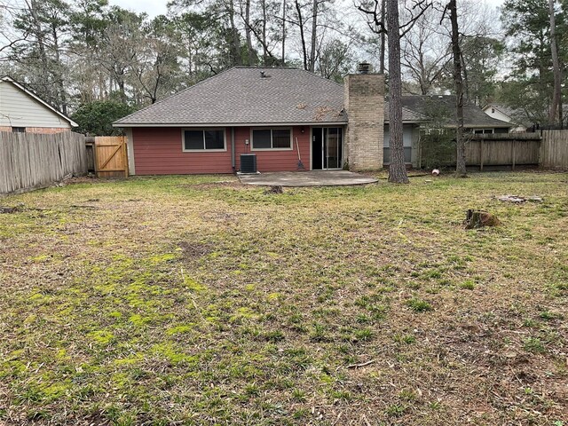 rear view of property featuring a patio, a yard, a fenced backyard, and central air condition unit