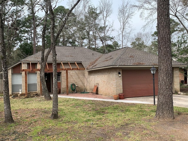 single story home with concrete driveway, brick siding, an attached garage, and a shingled roof