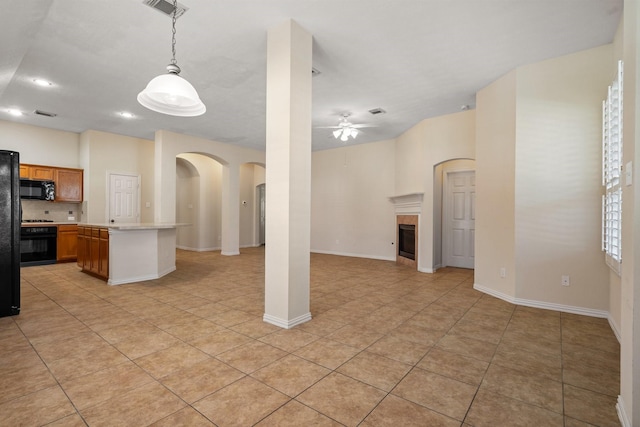 kitchen featuring ceiling fan, a fireplace, open floor plan, light countertops, and black appliances