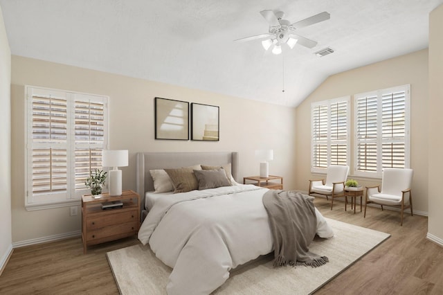 bedroom featuring baseboards, visible vents, a ceiling fan, wood finished floors, and vaulted ceiling