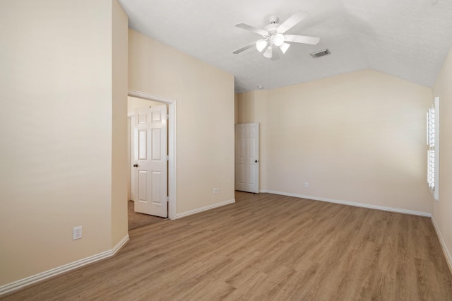 unfurnished room featuring lofted ceiling, light wood finished floors, baseboards, and visible vents