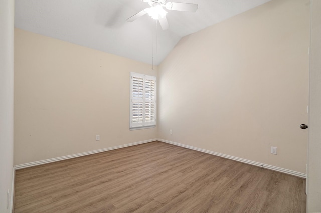 unfurnished room with lofted ceiling, baseboards, a ceiling fan, and wood finished floors