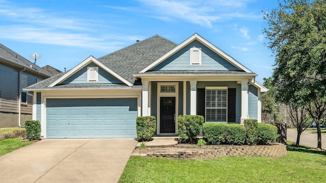 view of front of house with a garage, driveway, and a shingled roof