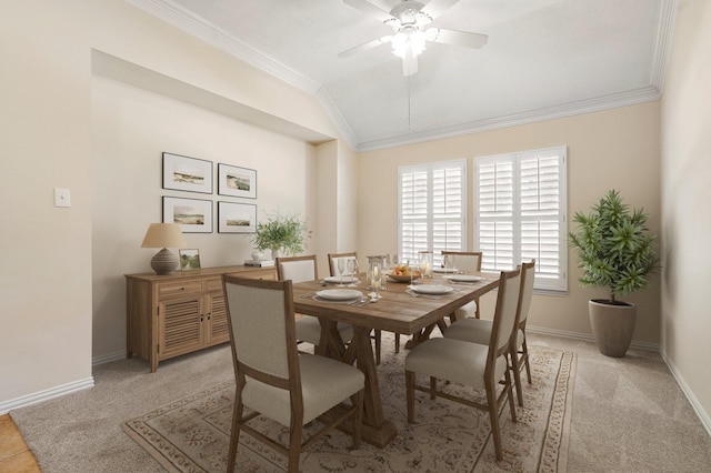 dining area featuring vaulted ceiling, baseboards, light carpet, and crown molding