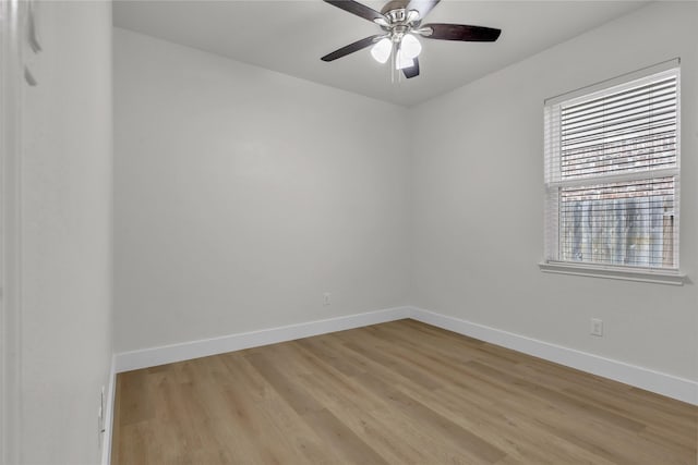 spare room featuring light wood-type flooring, ceiling fan, and baseboards