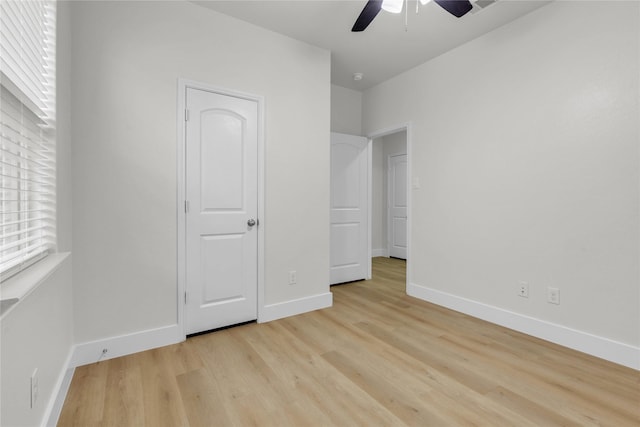 unfurnished bedroom featuring baseboards, ceiling fan, and light wood-style floors