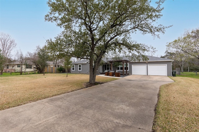 ranch-style house featuring an attached garage, driveway, fence, and a front yard