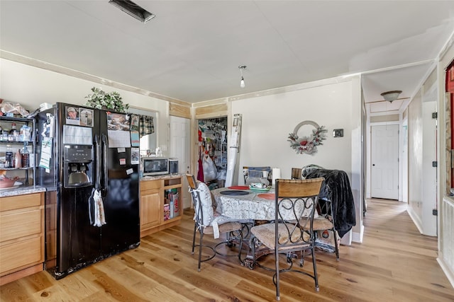 dining space featuring light wood-style flooring and baseboards