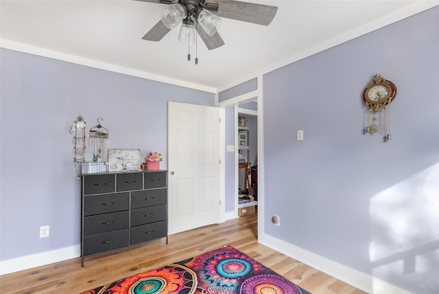 bedroom with light wood-type flooring, ceiling fan, and baseboards