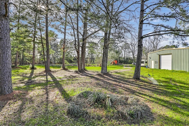 view of yard with driveway and an outbuilding