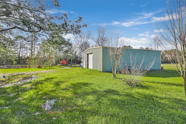 view of yard featuring driveway, a detached garage, a pole building, and an outdoor structure