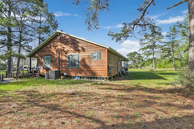 view of side of property featuring central AC unit and a yard