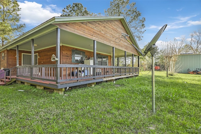 rear view of house featuring covered porch and a yard